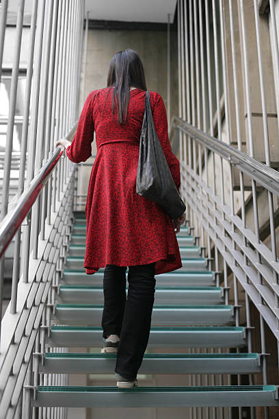 istock Young woman standing on the stairs 506288310