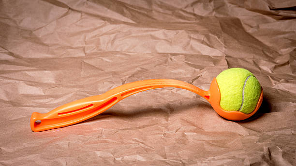 Tennis ball launcher with an orange handle stock photo