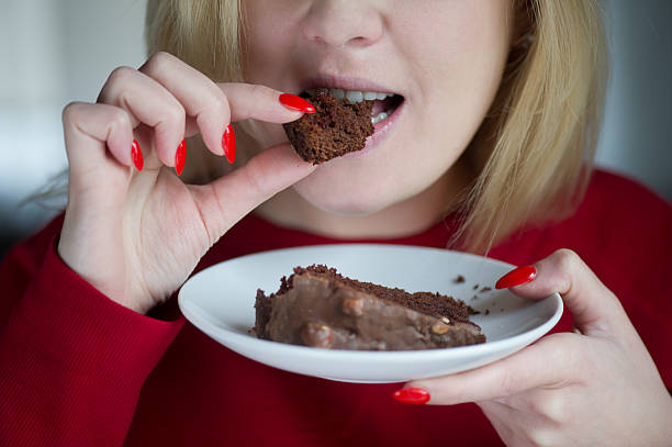 istock Girl biting a piece of chocolate cake 506288989