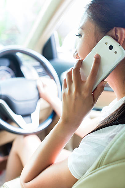 азиатская женщина, используя телефон вождение автомобиля - driving mobile phone car talking стоковые фото и изображения