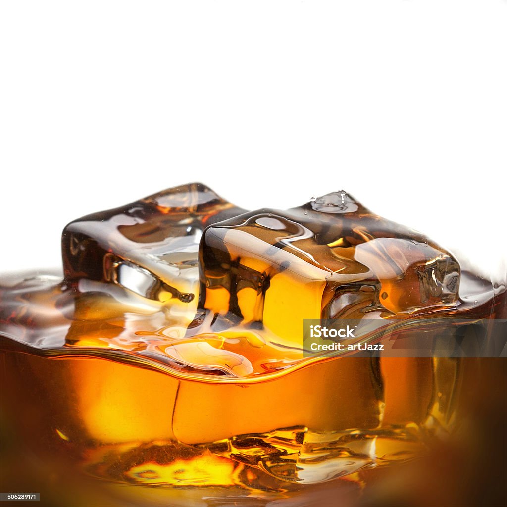 Splash of whiskey with ice in glass isolated on white Splash of whiskey with ice in glass isolated on white background Alcohol - Drink Stock Photo