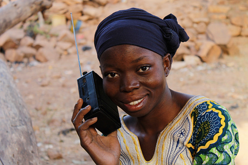 A girl listening to the radio while smiling