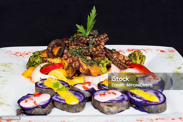 Grilled Octopus Gourmet Dish From Peru Served With Purple Potatoes Stock Photo - Download Image Now