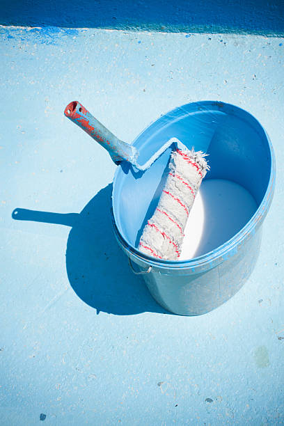 istock Painting a huge blue Swimming Pool. A maintenance worker pool 506292180