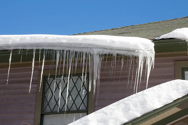 istock Icicles and snow falling off a home roof 506293826