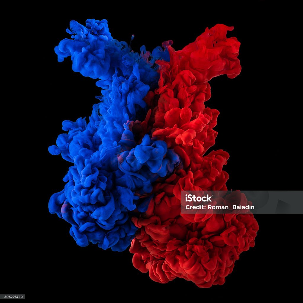 Plumes of red and blue ink in water Paint in water. Red and blue blending together on black background Two Objects Stock Photo