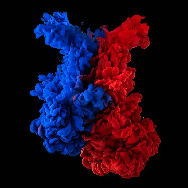 Paint in water. Red and blue blending together on black background