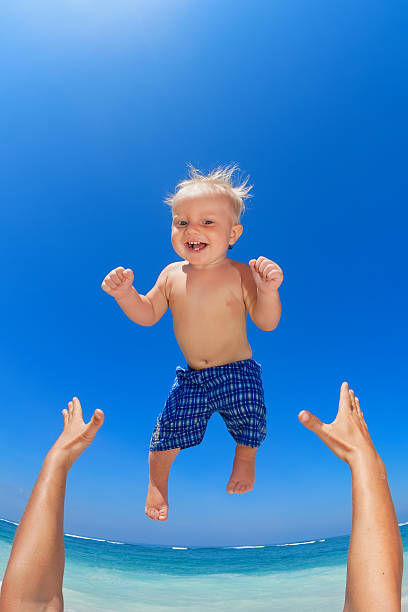 istock Father throwing up in the air a happy child 506296812