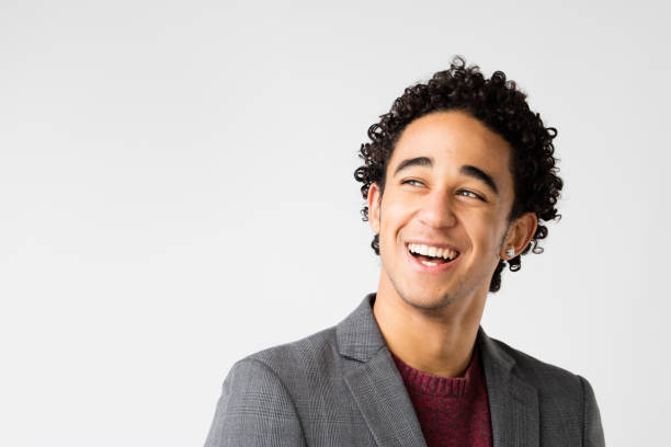 istock elegant young man with curly hair laughing 506297260