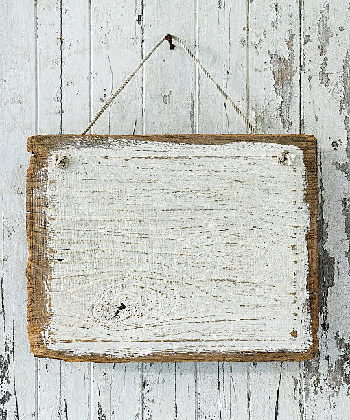 istock Old weathered white wood signboard hanging from an old nail. 506297322