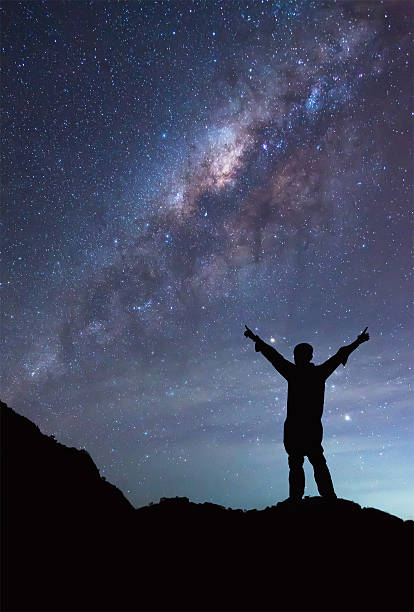istock Man is standing next to the Milky Way , spread hand 506297918