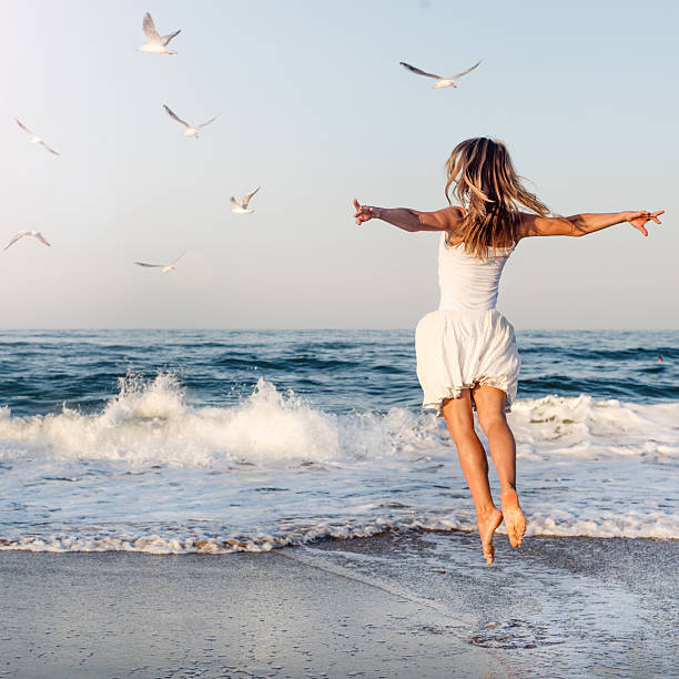istock Beautiful girl  jumping on sea 506299610