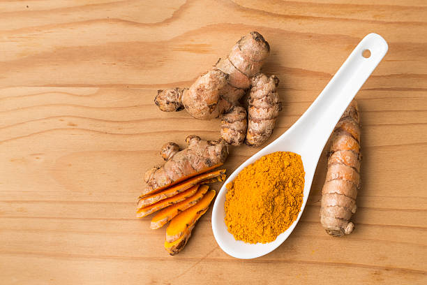 istock Fresh and grounded turmeric roots on wooden surface 506317210