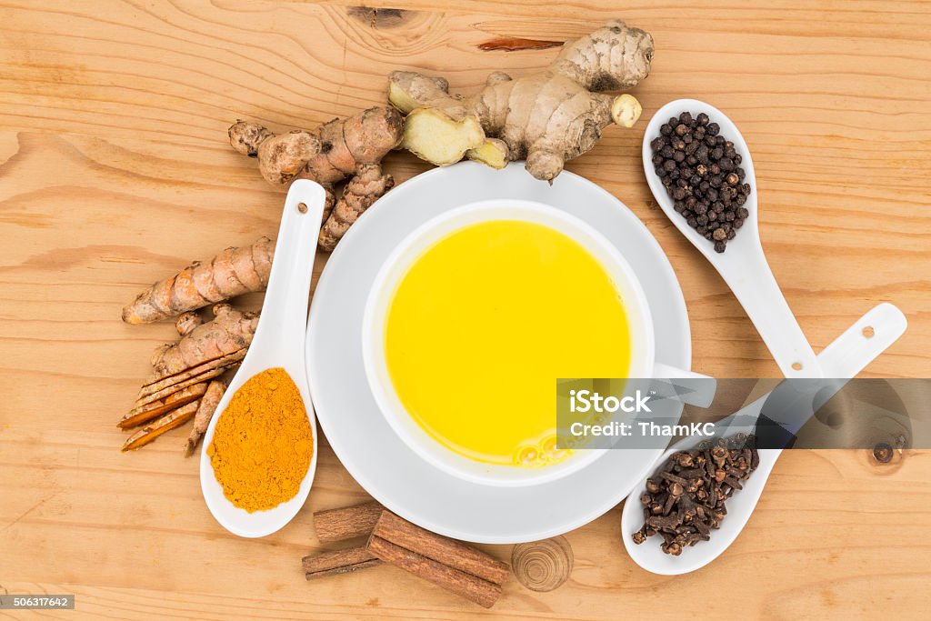 Healthy turmeric milk tea with ginger, cinnamon, cloves, black p Aromatic milk tea with ginger roots, cinnamon, cloves and black pepper offers many wellness health benefits Antioxidant Stock Photo