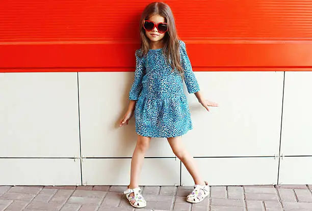 Photo of Beautiful little girl model wearing a leopard dress and sunglass