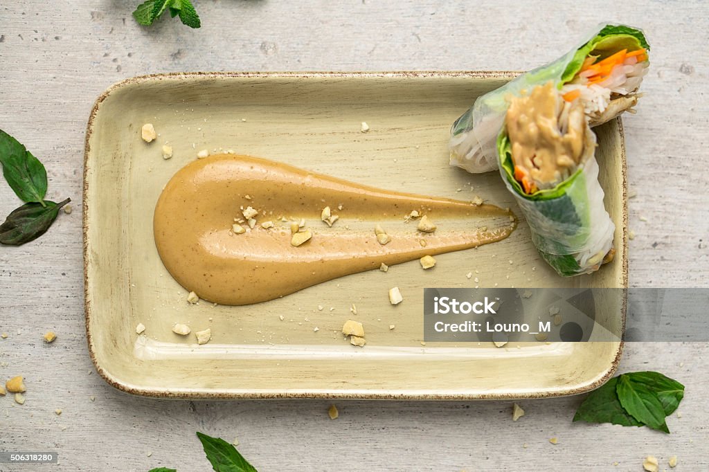 Peanut Butter Sauce And Spring Rolls Top View Overhead view of a delicious peanut butter sauce with vietnamese style fresh spring rolls. Peanut Butter Stock Photo