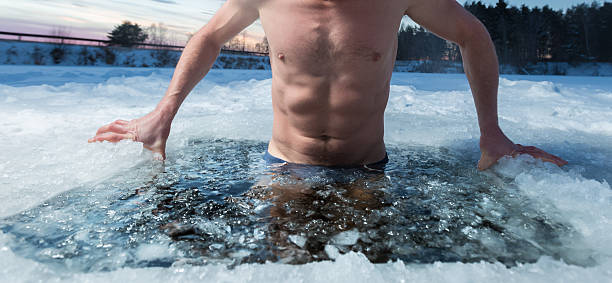 Ice hole swimming Young man bathing in the ice hole. Focus on the ice in a water only just do it stock pictures, royalty-free photos & images
