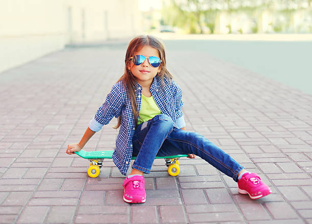 moda mała dziewczynka dziecko siedzi z deskorolka w mieście - cool glasses sunglasses fashion zdjęcia i obrazy z banku zdjęć