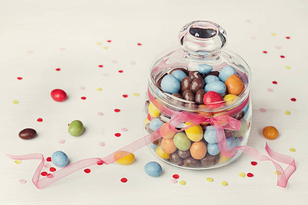 istock Sweets or candy in jar with confetti, holiday concept 506320978