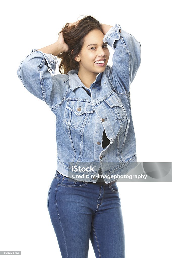 Cute girl smiling with hands in hair wearing jeans Portrait of a cute girl smiling with hands in hair wearing jeans isolated on white background 20-29 Years Stock Photo