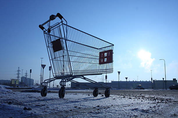 Image of empty shopping cart on empty parking near huge store stock photo