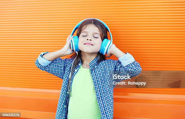Happy Smiling Child Enjoys Listens To Music In Headphones Stock Photo - Download Image Now