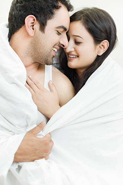 Attractive couple together on bed doing romance. stock photo