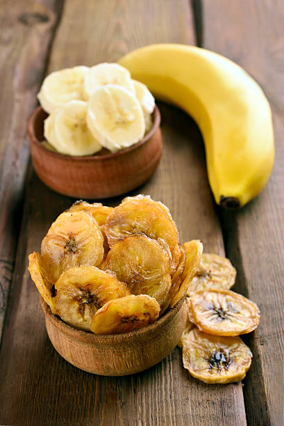 istock Banana chips on wooden table 506329098