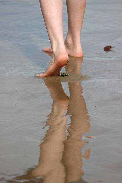 mädchen zu fuß auf wet beach und reflections im sand und meer - human foot wading sea human toe stock-fotos und bilder