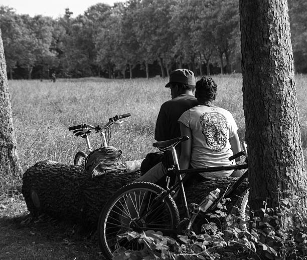 Paris, France - June 16, 2013: Unidentified man and woman rest and smoke in Vincennes park after biking. Vincennes park is the largest park of Paris which is very popular on weekends among Parisians