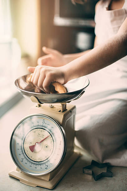 istock Little boy weighs cookies on kitchen scale 506343070