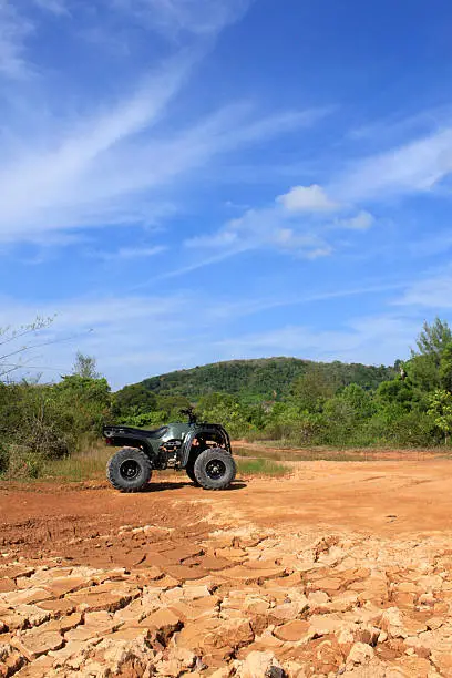 ATV stands on the ground in rubber tree field