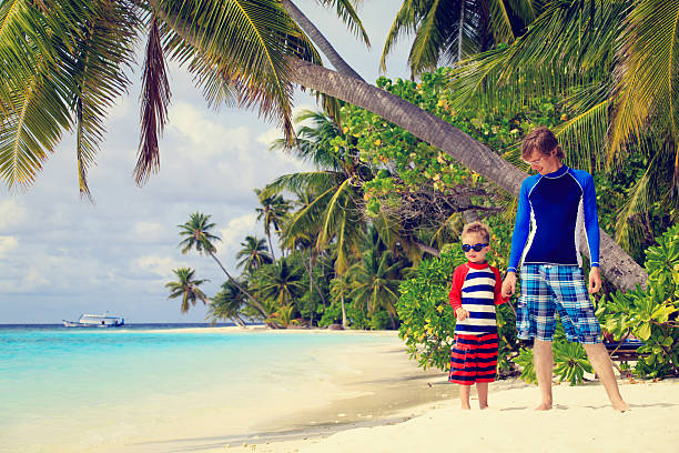 istock father and son holding hands on the beach 506346994