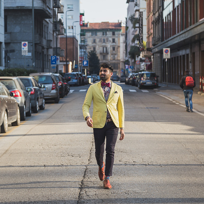 Portrait of an Indian young handsome man walking in an urban context