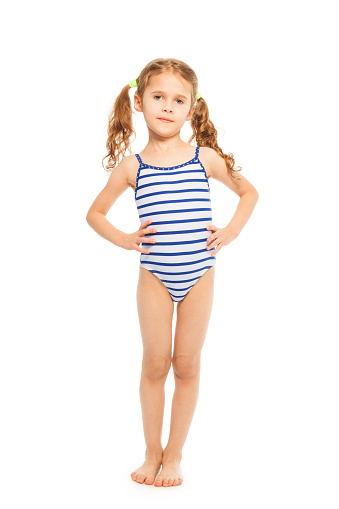 Little model standing full length in stripped swimming suit isolated on white
