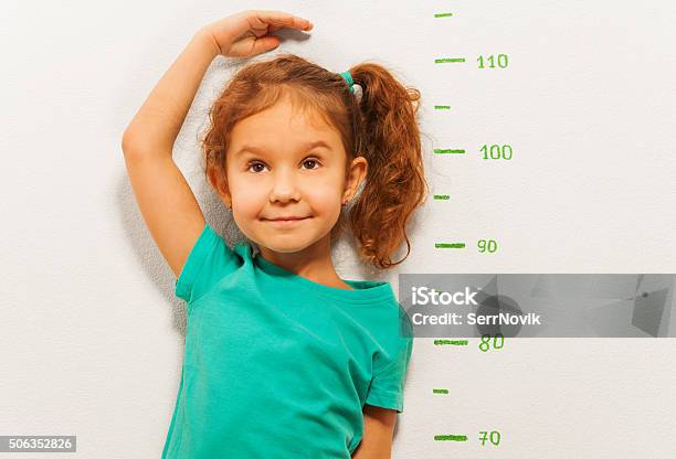 Close Portrait Of A Girl Show Height On Wall Scale Stock Photo - Download Image Now - Child, Growth, Human Height