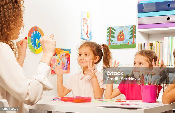 Two Pupils Doing Finger Exercises As Their Teacher Stock Photo - Download Image Now - Adult, Baby - Human Age, Baby Girls