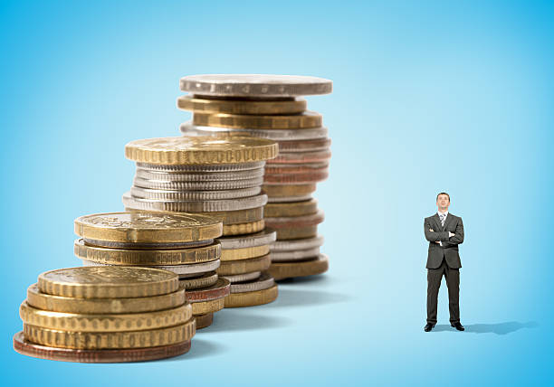 istock Businessman in front of coins 506354940