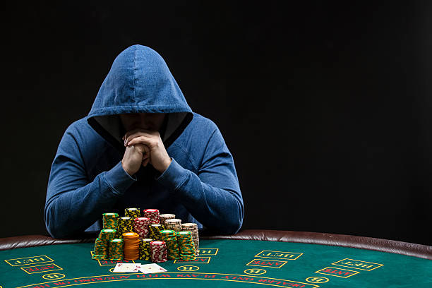 Poker player looking at combination of two aces. Closeup Poker player sitting at a poker table with chips table trying to hide his expressions and looking at combination of two aces. Closeup texas hold em photos stock pictures, royalty-free photos & images