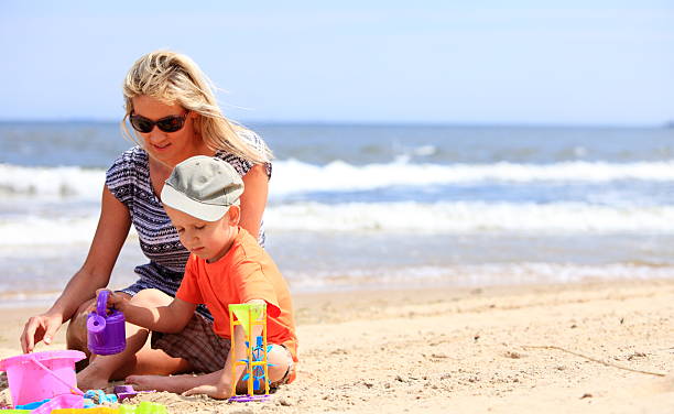 istock Son and mother playing toys on beach 506362195