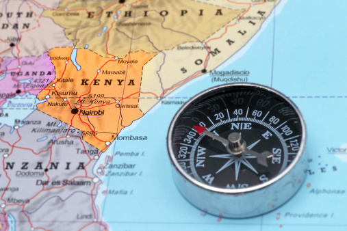 Compass on a map pointing at Kenya and planning a travel destination