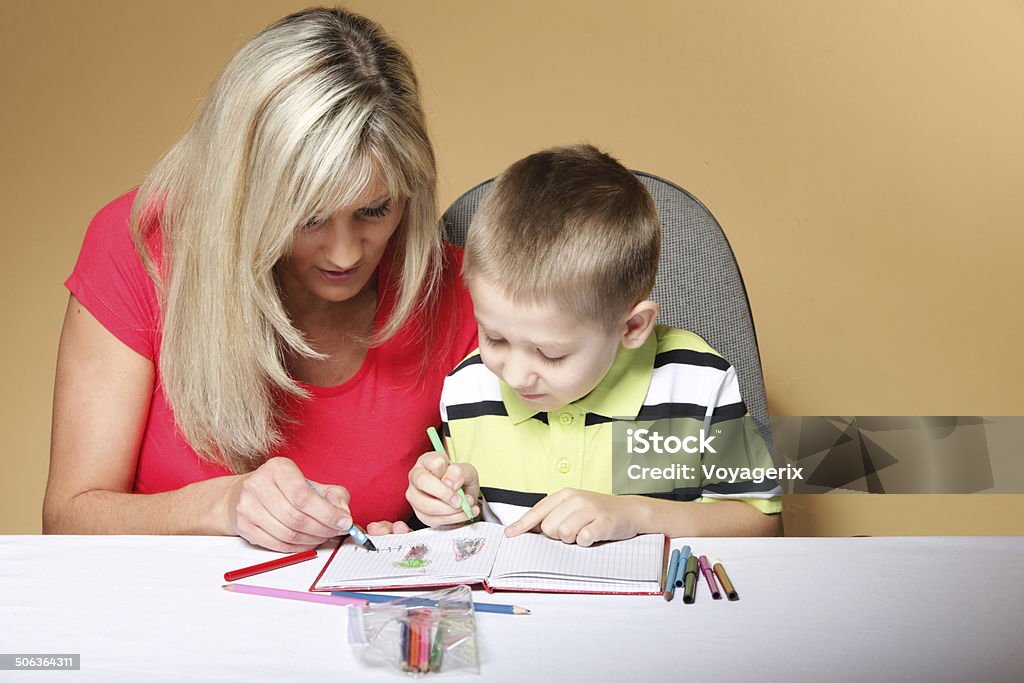 mother and son drawing together mother and son drawing together, mom helping with homework daycare brown background 6-7 Years Stock Photo