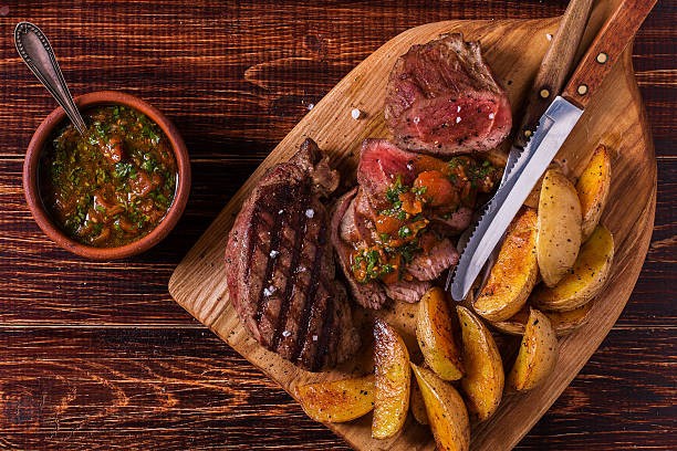 istock Grilled steak with potato wedges, salsa and spices. 506387718