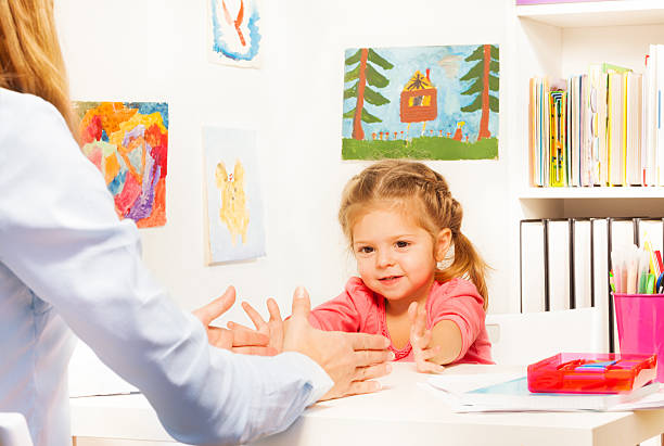 istock Little preschooler doing finger exercises at table 506387802