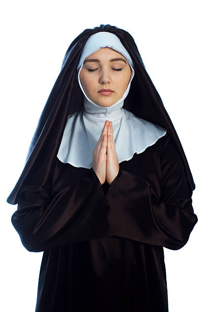 Young attractive nun. Young nun prays. Photo on white background. nun catholicism sister praying stock pictures, royalty-free photos & images
