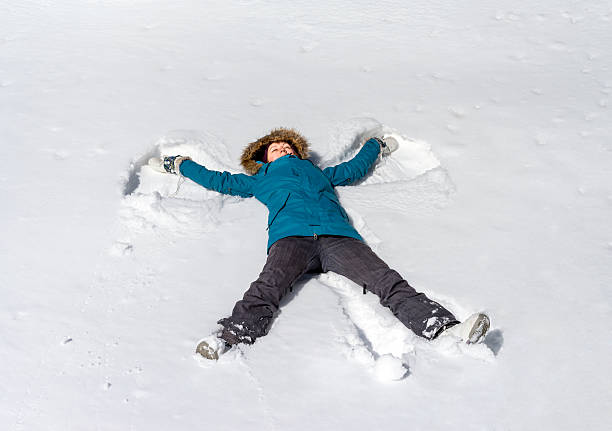 istock Young woman, creating a snowy angel figure 506389670