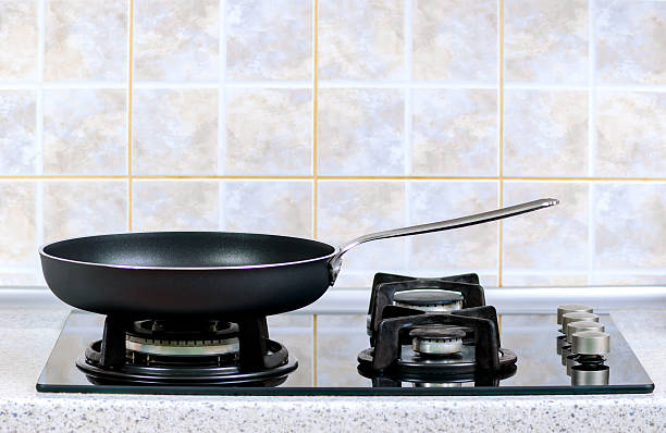 frying pan on the gas stove the frying pan taken closeup on a gas stove electromagnetic induction stock pictures, royalty-free photos & images