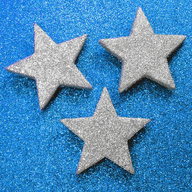istock three large silver stars on bright red glittery background 506391410