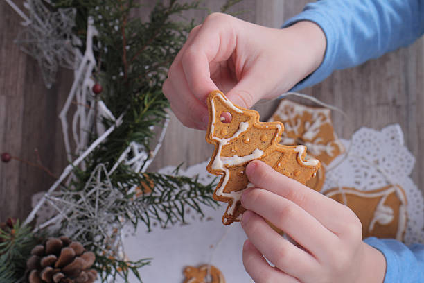 istock Kid making christmas tree decoration from gingerbread cookie 506392234