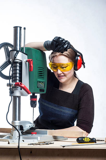 istock female carpenter and drilling machine. 506393222